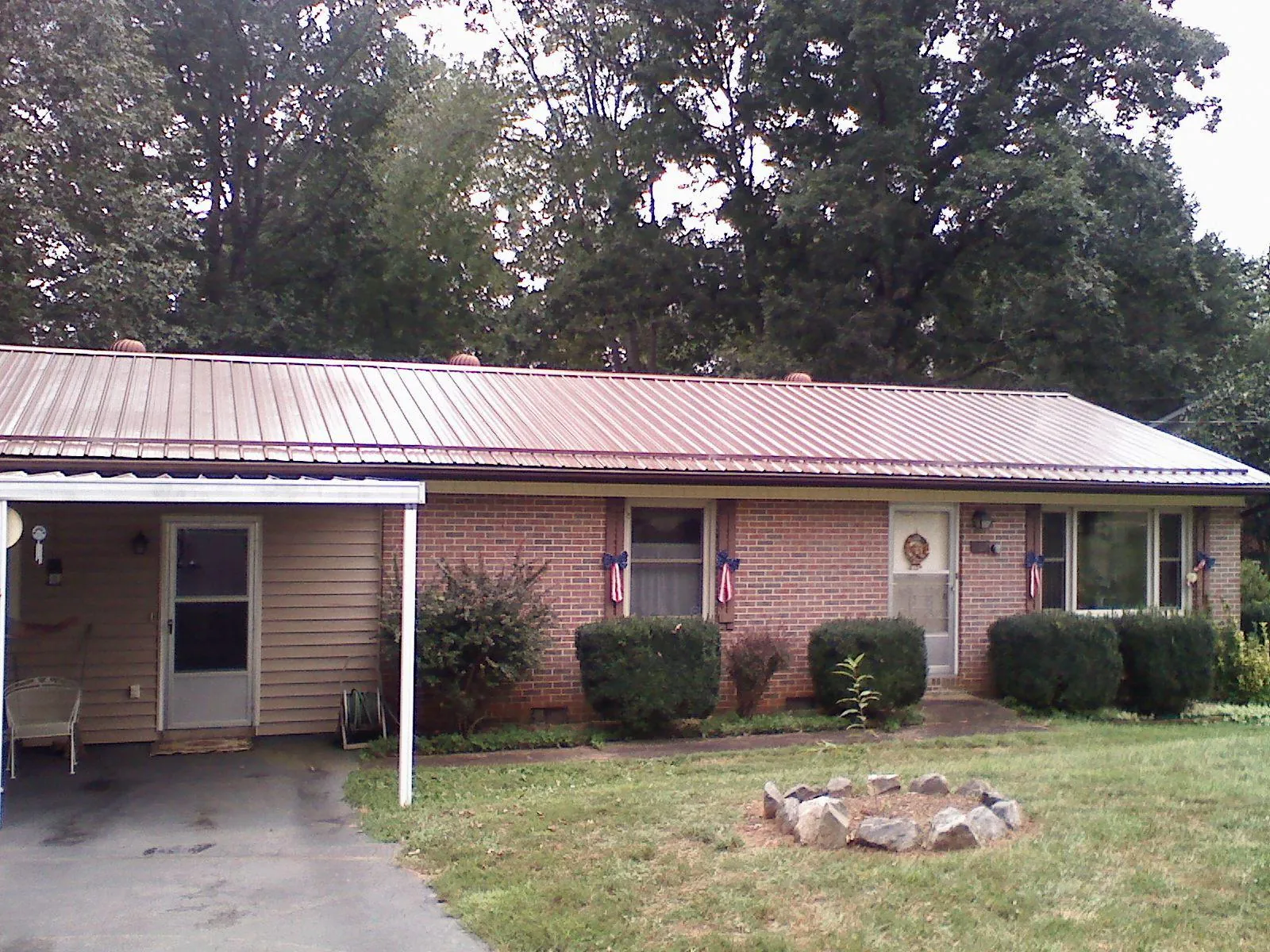 Bronze metal roof and carport on a brick ranch home — Roof Repair work by our crew in Mount Carmel